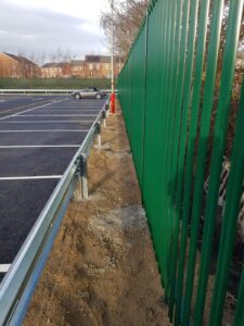 ECO-MSE retaining wall supporting Normanton Station Car Park with vehicle barrier and palisade fencing installed behind.